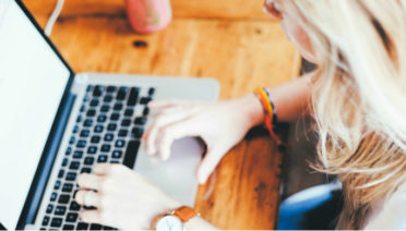Woman typing on a laptop with a multi-tasking writing style.