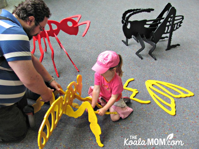 Daddy and preschooler building wooden bugs at the Pacific Science Center in Seattle.