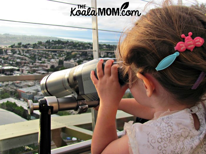 Toddler using a telescope to view Seattle from the Space Needle