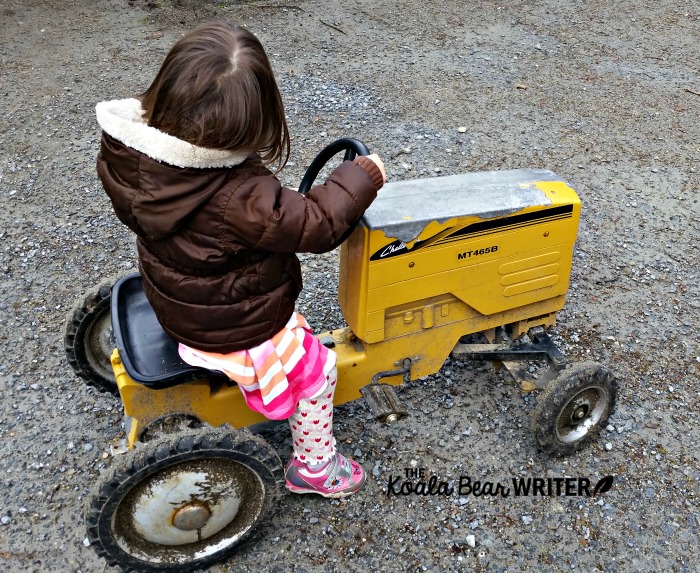 Toddler riding a mini tractor at an educational farm in North Vancouver.