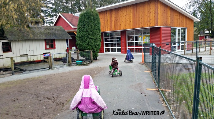 Three girls riding mini tractors at Maplewood Farm in Vancouver, BC