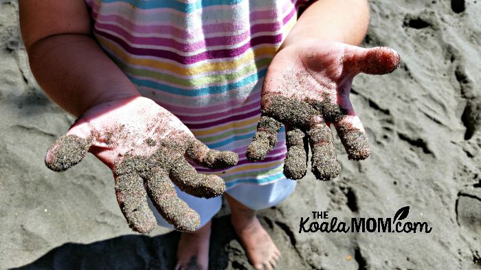Jade's sandy hands at Mystic Beach