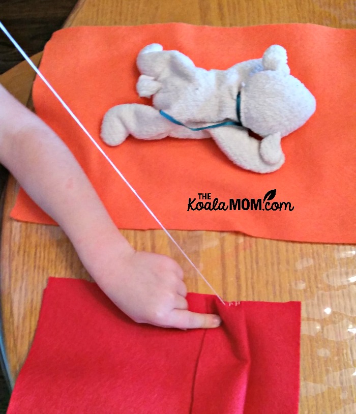 Lily sewing a sleeping bag for her stuffed lamb