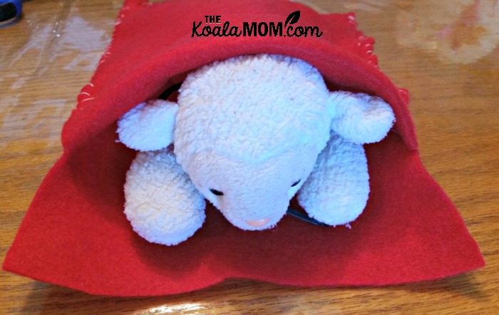 Beany Baby lamb tucked inside her felt sleeping bag