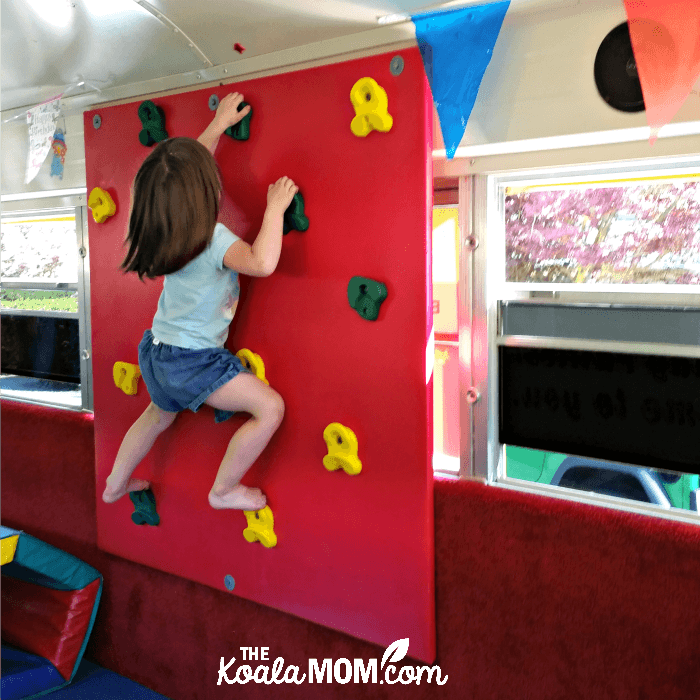 Toddler climbing a wall at a Fun GymBus birthday party