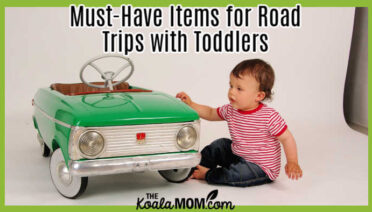 Must-Have Items for Road Trips with Toddlers. Image of toddler looking at green ride-in-car by coolunit from Pixabay.