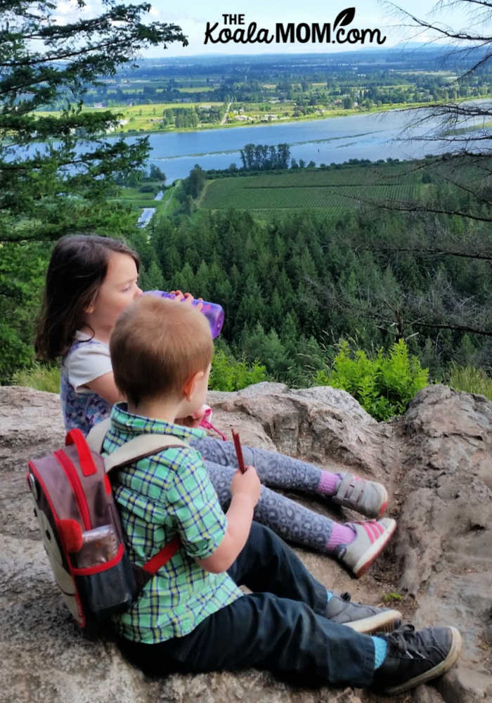 Siblings having snacks at the viewpoint on the trail.