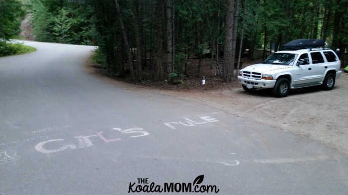 "GIRLS RULE" in sidewalk chalk on the pavement in front of our campsite.