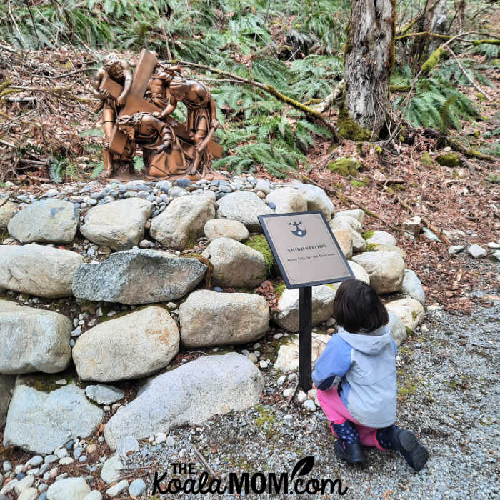 Five-year-old kneels at the third Station of the Cross at Little Carmel Monastery.