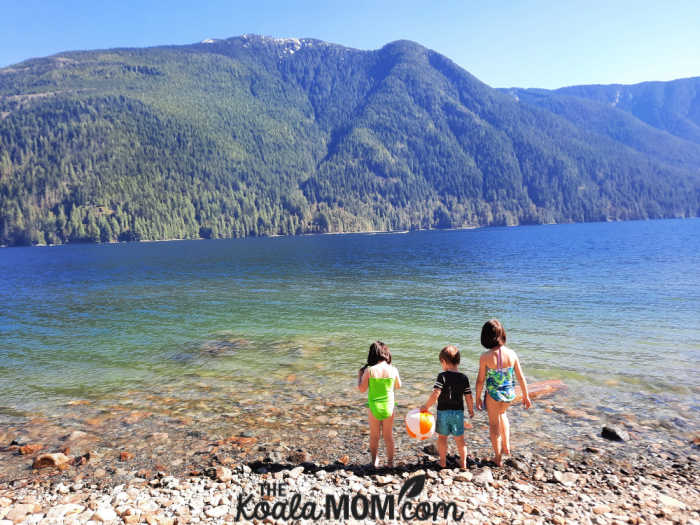 Three kids stand on the edge of Alouette Lake in Golden Ears Provincial Park.