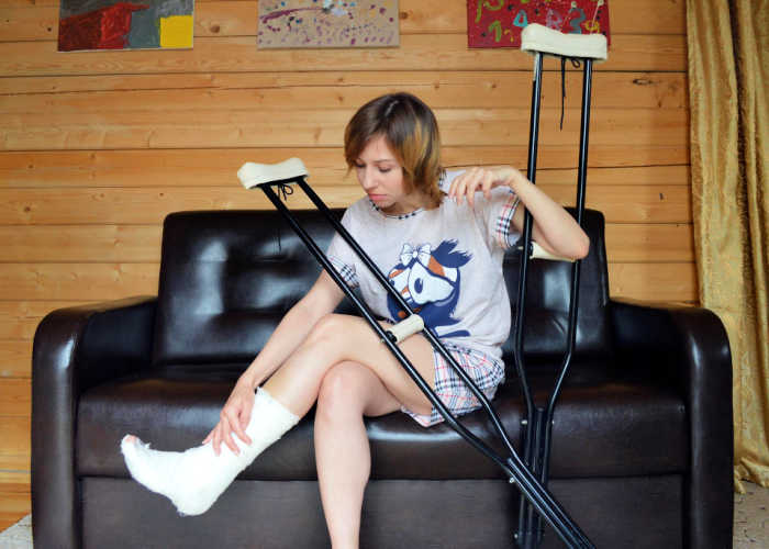 Woman with crutches recovering after a car accident.