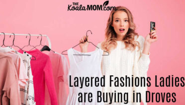 The Layered Fashions Shoppers are Buying in Droves. Photo of woman choosing an outfit from a rack with a pink background via Depositphotos.