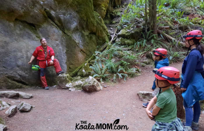 Cave tour guide tells four kids about limestone rocks and cave formation.