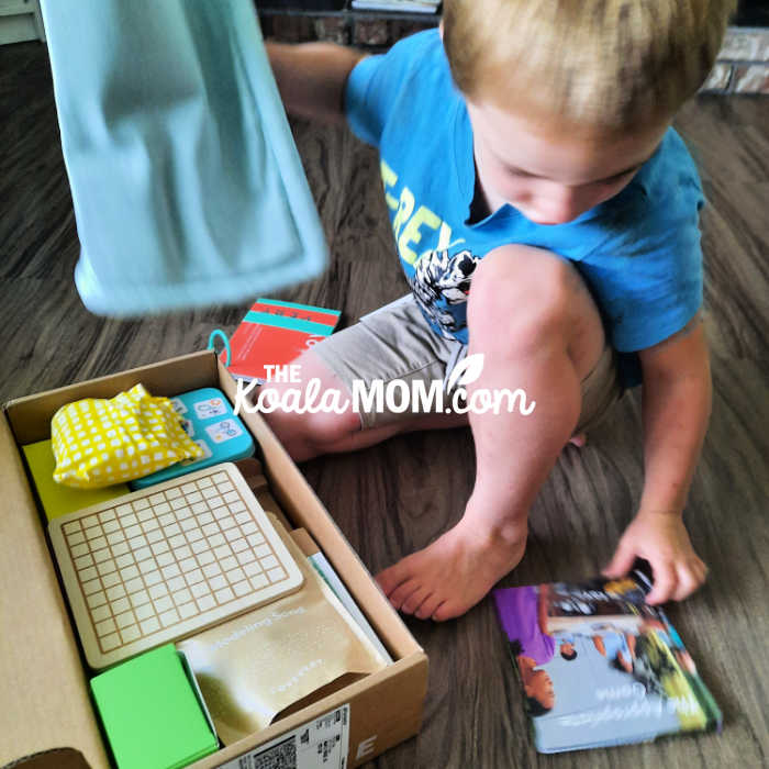 Joey starts to open his new Lovevery play kit.