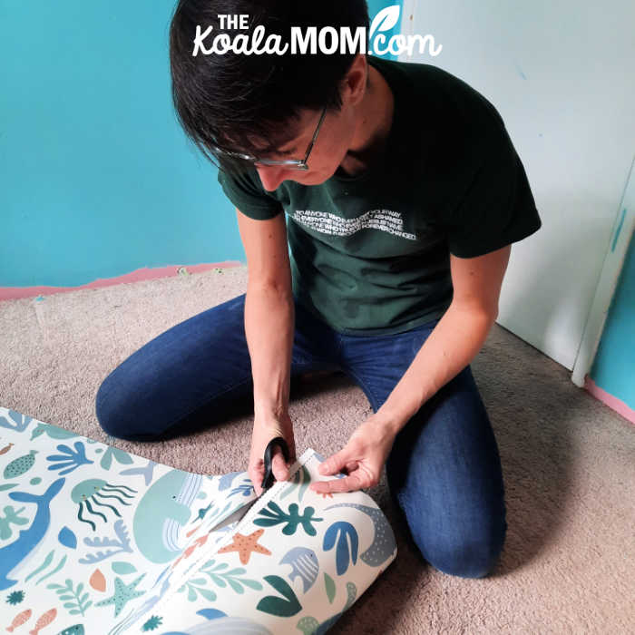 Cutting apart each section of the wallpaper before hanging it.