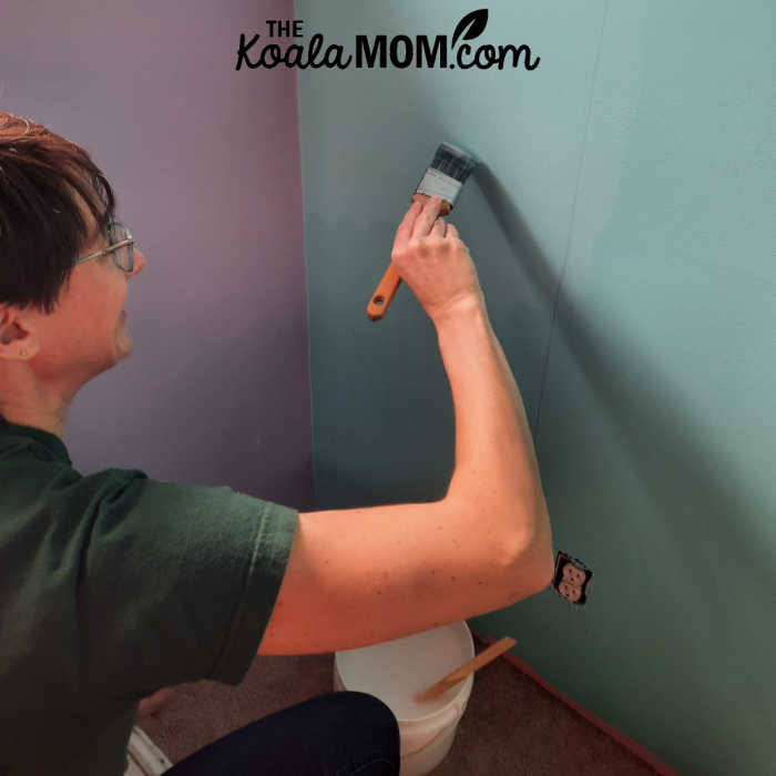 Spreading wallpaper paste on a wall.