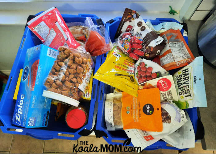 Two shopping bins filled with backpacking snacks for my kids.
