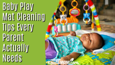 Baby Play Mat Cleaning Tips Every Parent Actually Needs. Photo of cute baby laying in a play mat with toys overhead by DICSON via Unsplash.