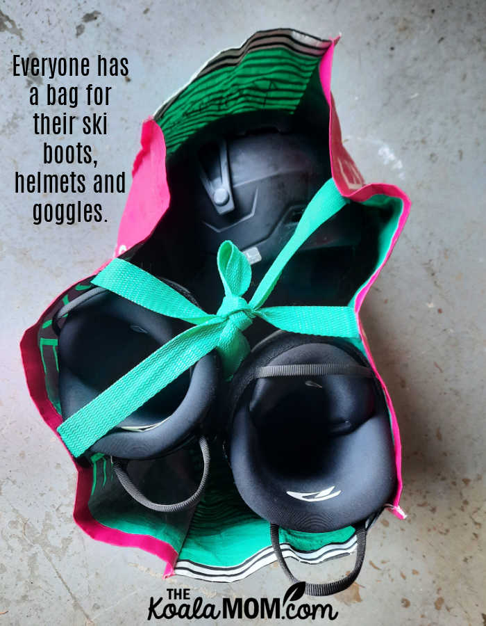 Everyone has a bag for their ski boots, helmets and goggles. Photo of black ski boots and helmet in a reusable grocery bag by Bonnie Way.