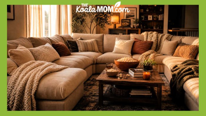 Stock photo of huge, u-shaped modular couch with throw blankets and cushions and a coffee table in the middle.